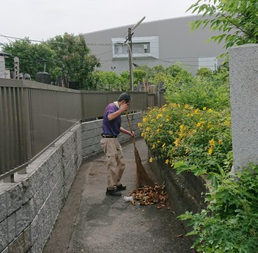 寺社間里道 福性寺のお掃除担当さんが清掃しています 堀船3丁目の町会副会長さんが植えた黄色い花がきれいです