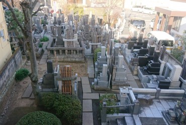 本堂の後ろにある墓地です 江戸時代からのお檀家の墓所が多いです 御影石の参道と土が見えます 右上にベンチのスペースがあります 1坪ぐらいです