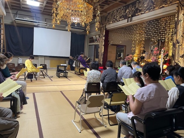 講演会後の読経 檀家様のお持ちの黄色の紙には般若心経と光明真言などが書かれています